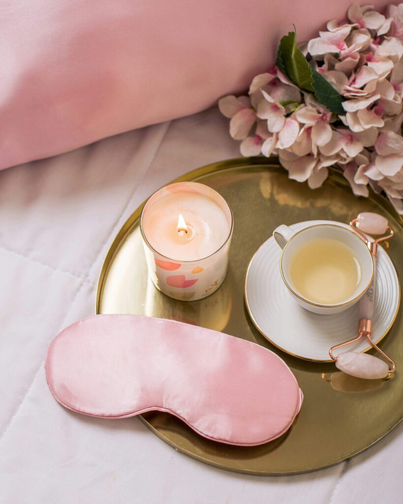 Cozy stocking stuffer ideas for her including cand;e, silk pillowcase, and self-care gifts