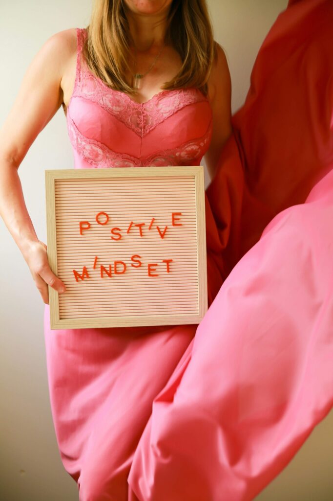 woman holding a sign that says positive mindset which is a benefit of self-love
