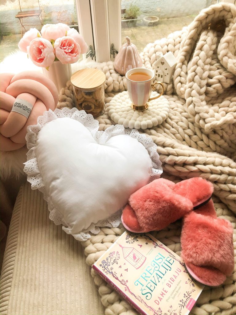 cozy self-care DIY basket essentials including blanket, slippers, and warm drink