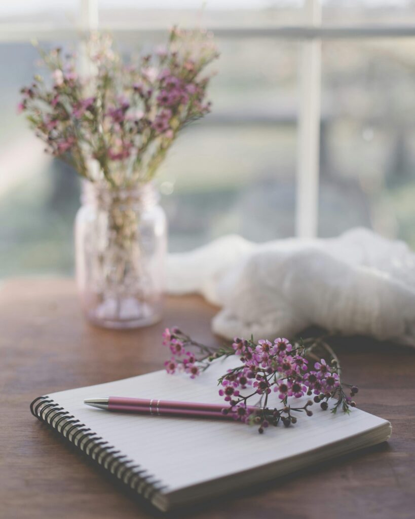 Open journal and pen on a table, representing journaling as a self-love practice.