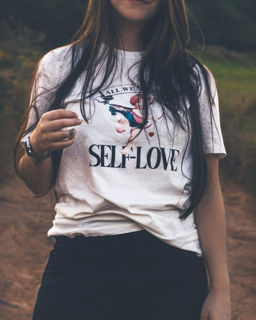 woman wearing a shirt that says "self-love"