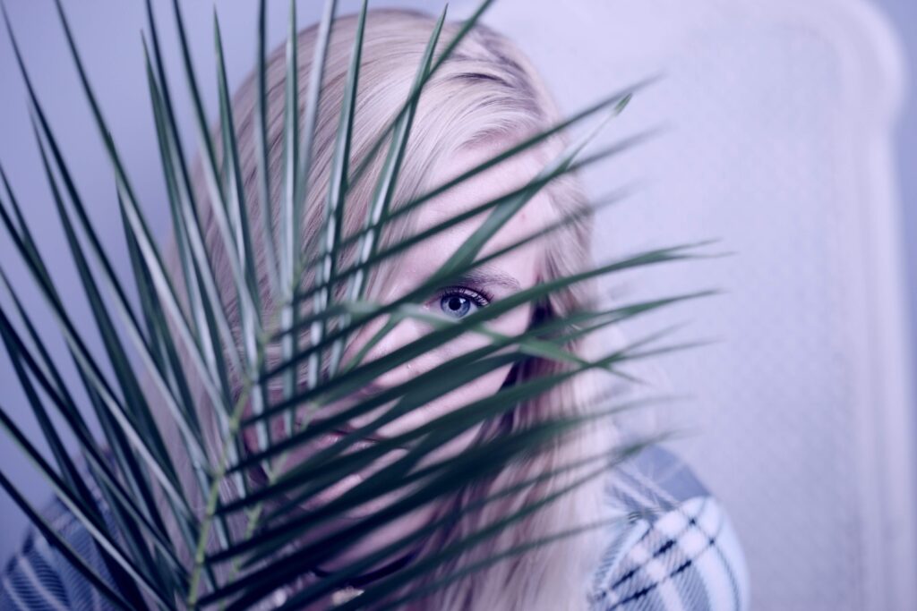 woman hiding behind a plant