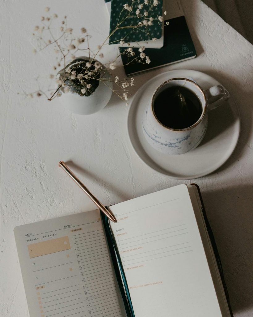 flat lay of planner, coffee and flowers