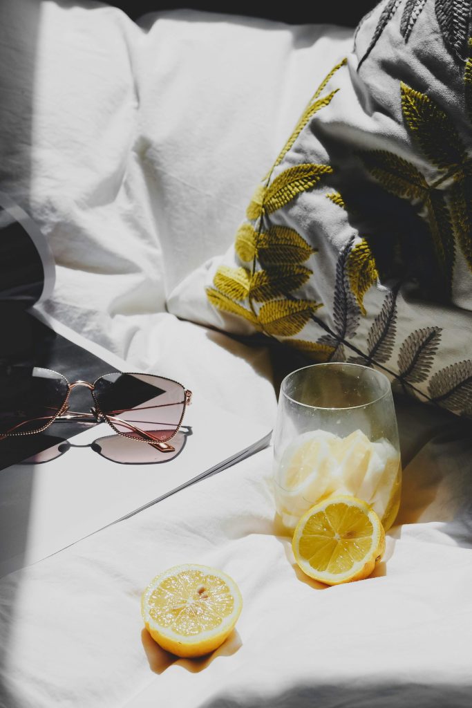 Summer beauty tips:  sunglasses, lemon water on a blanket