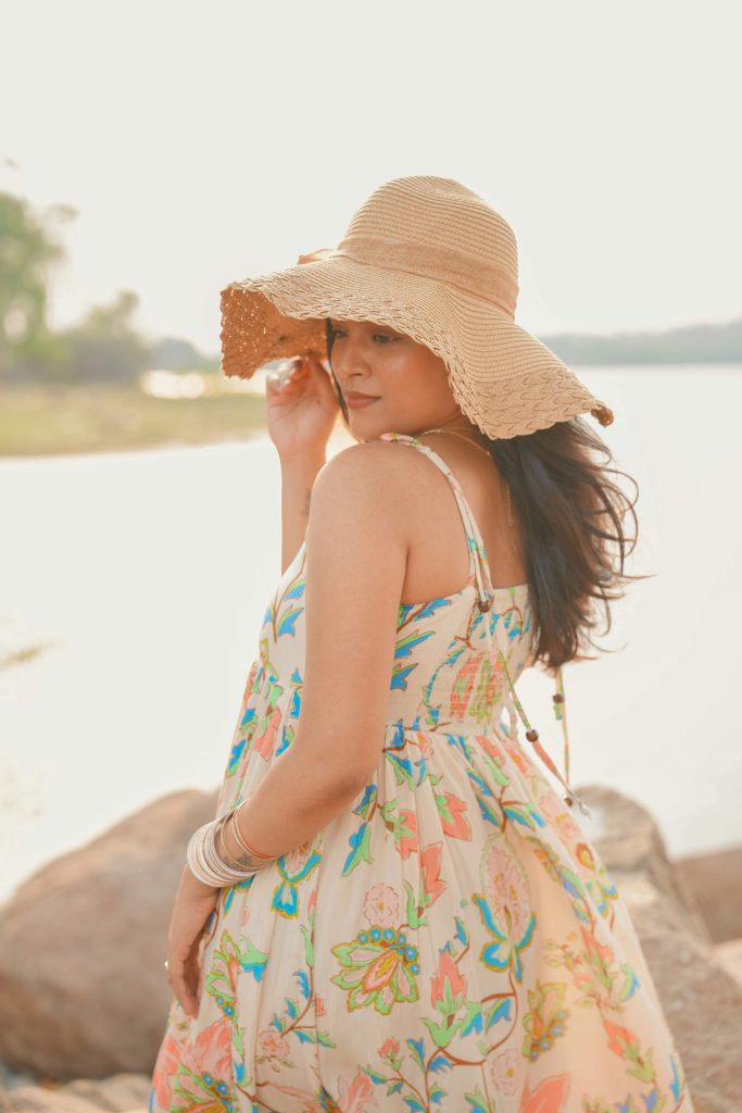 woman in a straw hat by the water.  A summer beauty tip