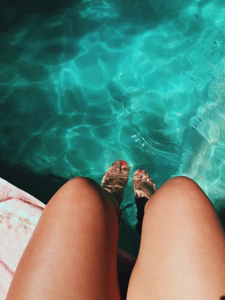 Cooling off with feet in a pool as a summer activity for adults