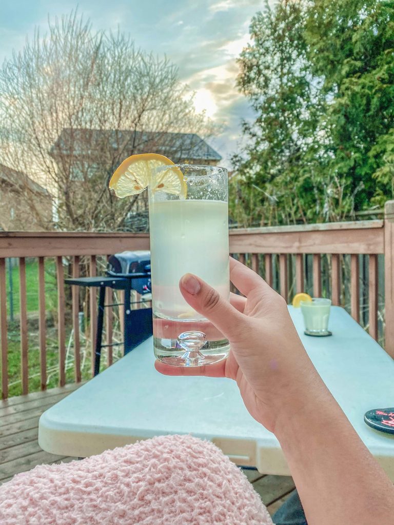 woman enjoying an iced drink on a deck as a summer activity for adults