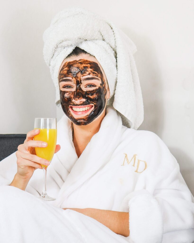 woman with charcoal face mask on as an act of self-care