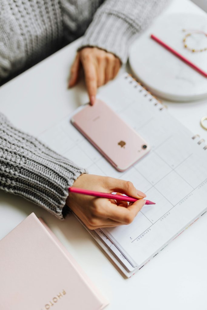 Woman using a planner to organize Christmas plans at home