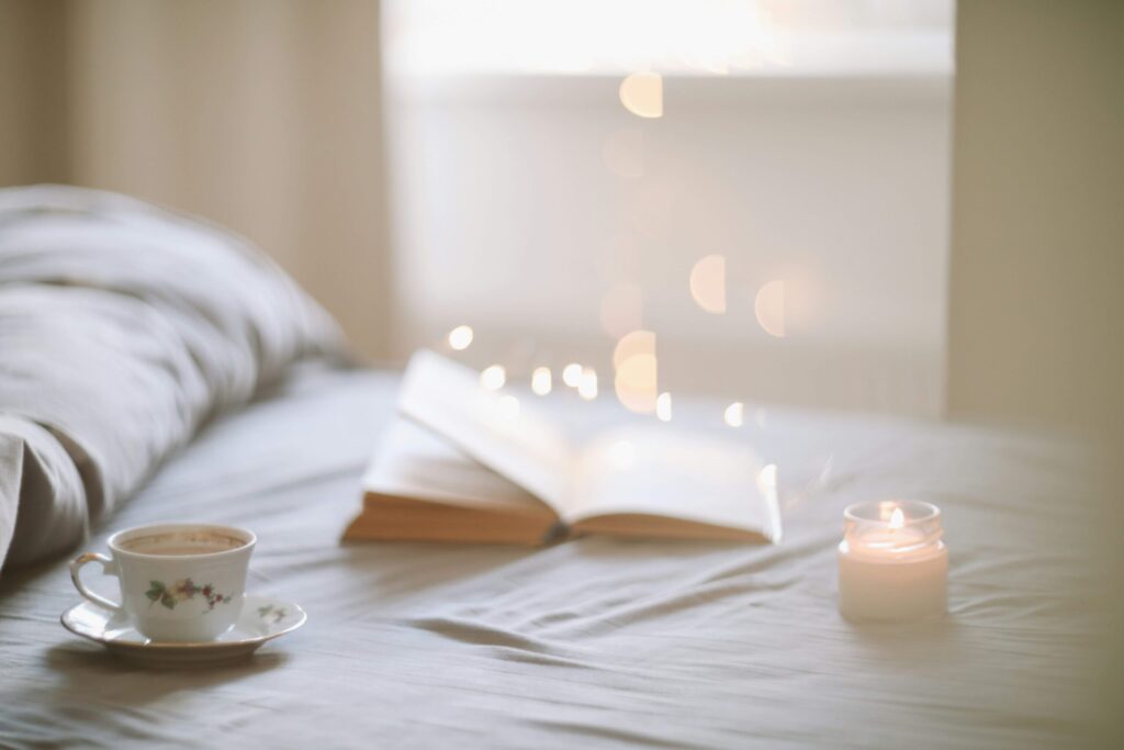 candles with a cup of tea and journal for self-care organization 