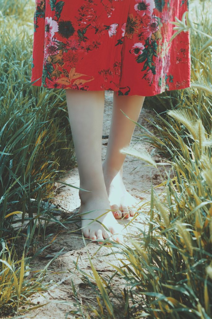 woman standing barefoot outside as a mindfulness practice 