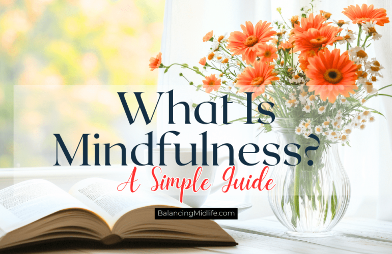 book and vase of flowers near a window reflecting what mindfulness is