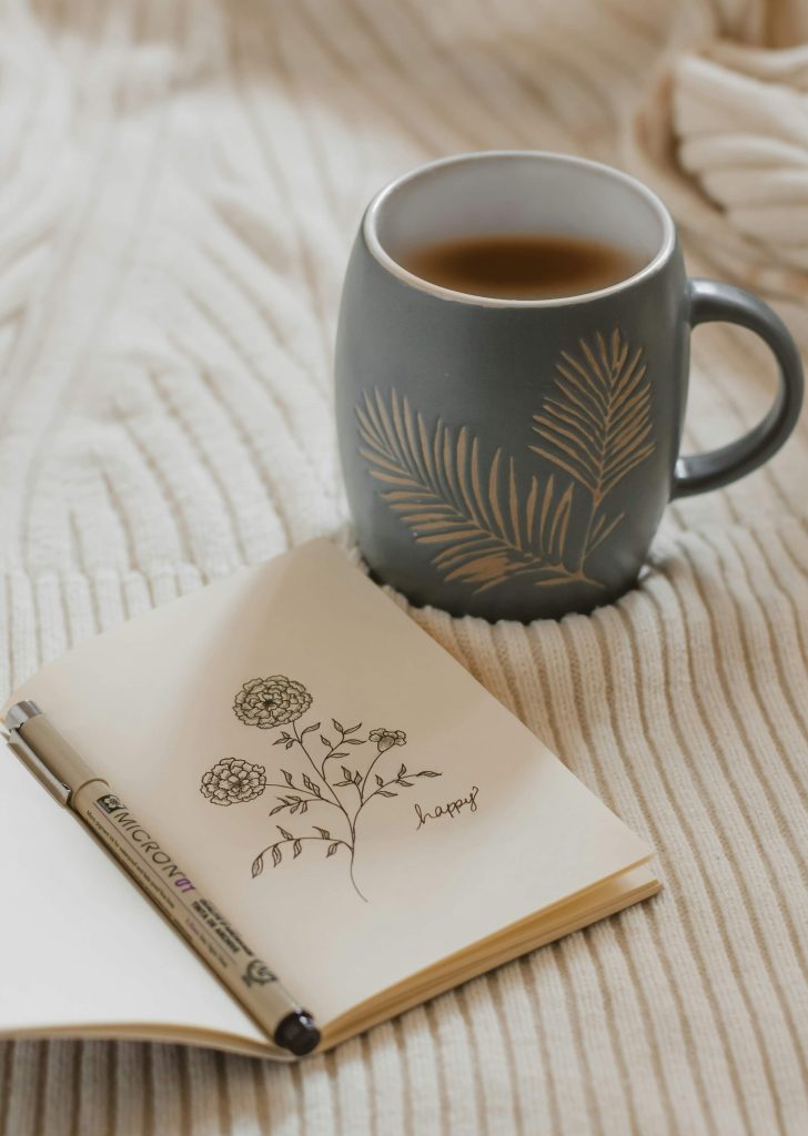 Journal and coffee creating a quiet moment of reflection for midlife self-care and personal growth.