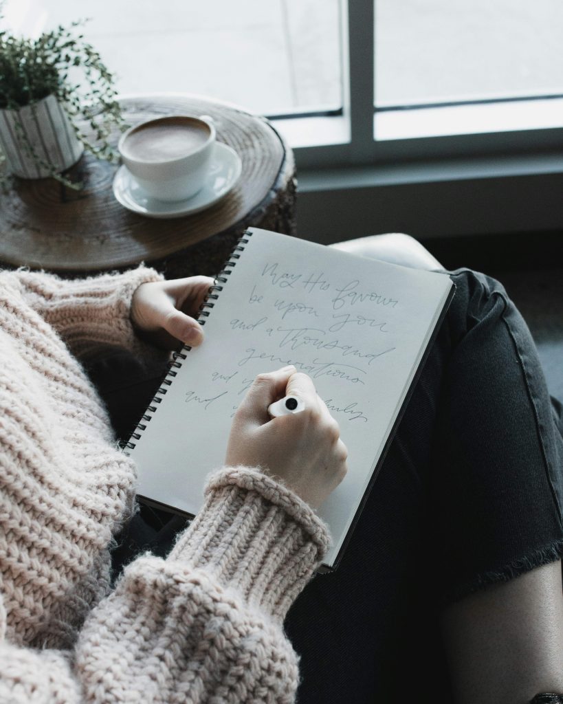 Woman writing in a journal at home during fall while creating a mindful journaling routine