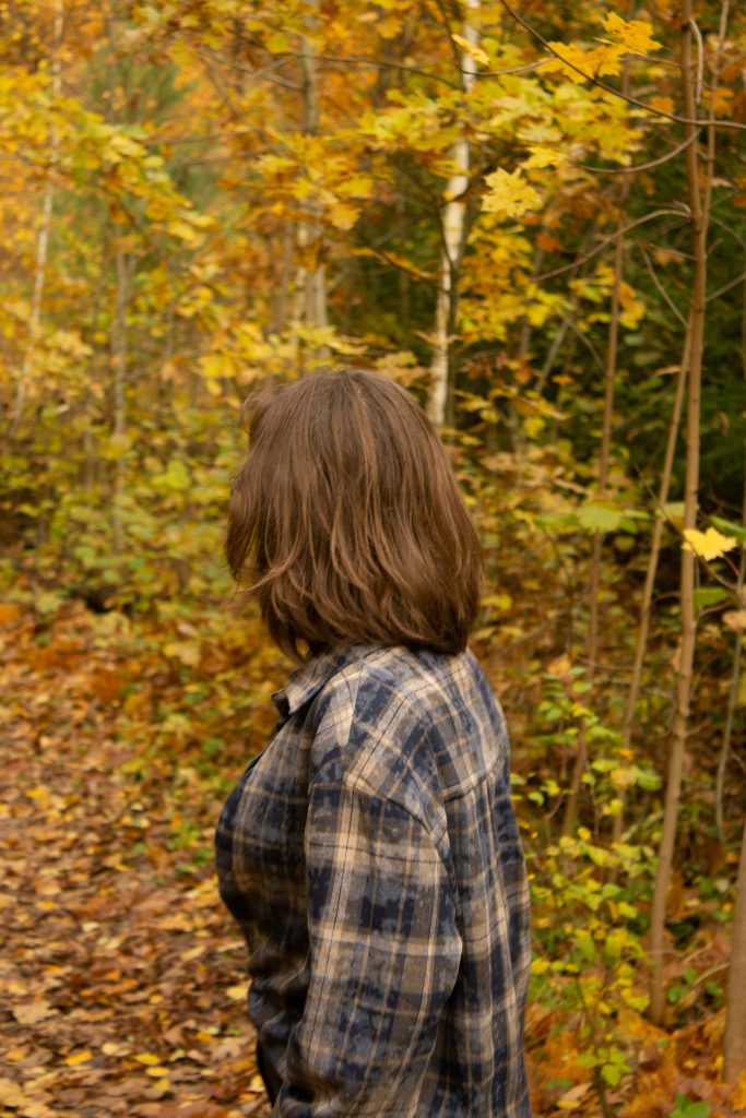 Woman enjoying a peaceful autumn walk while practicing mindfulness and reflection.