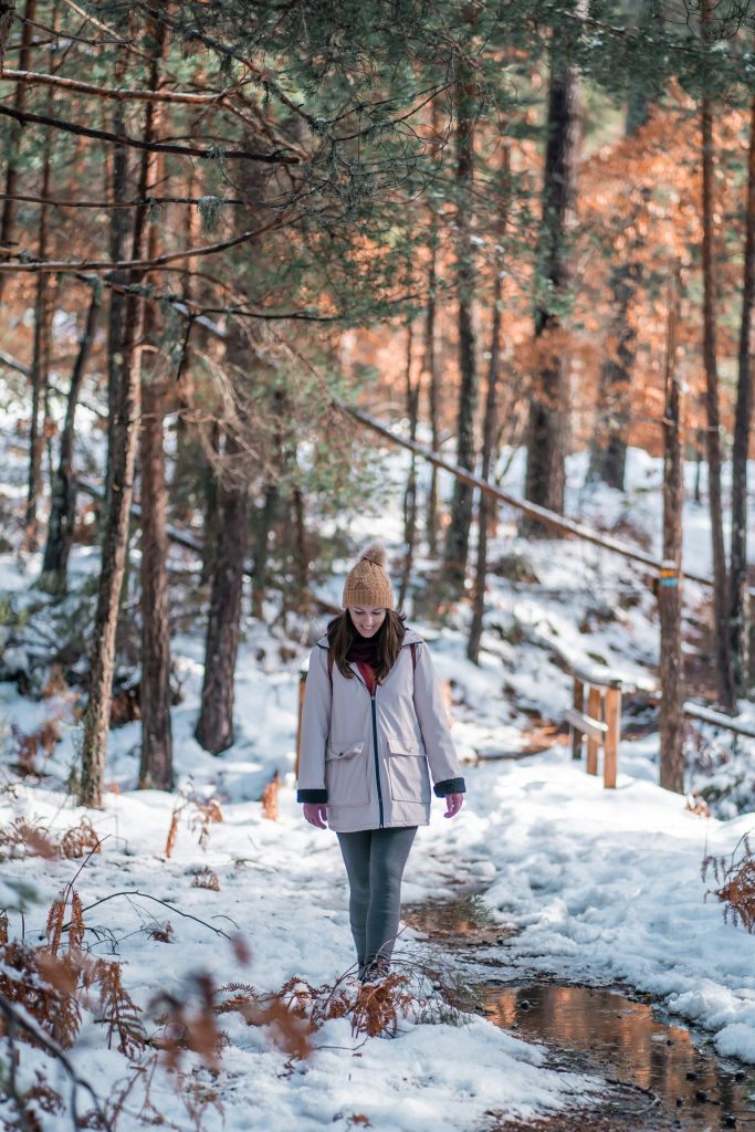 Woman taking a winter walk outdoors on a crisp day as part of a winter self-care challenge
