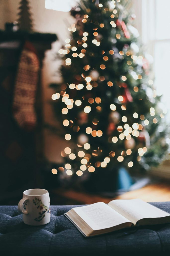 journal near a christmas tree as part of holiday self-care/quiet time
