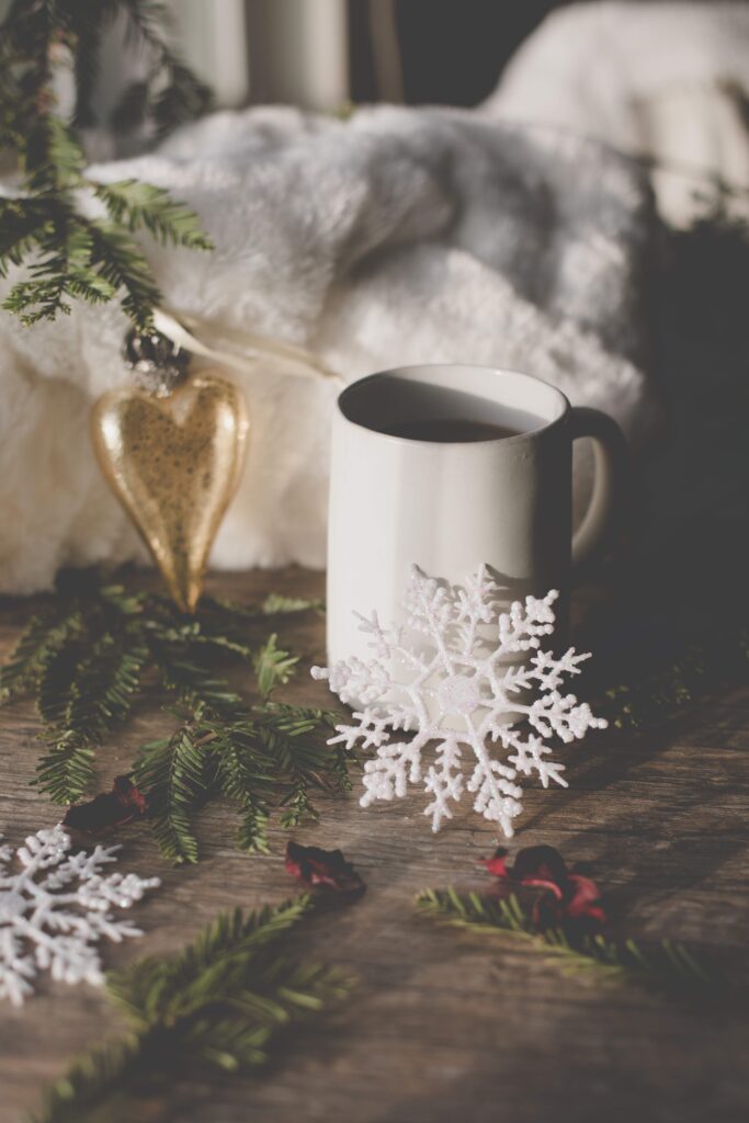 Cup of coffee surrounded by Christmas decorations representing holiday self-care
