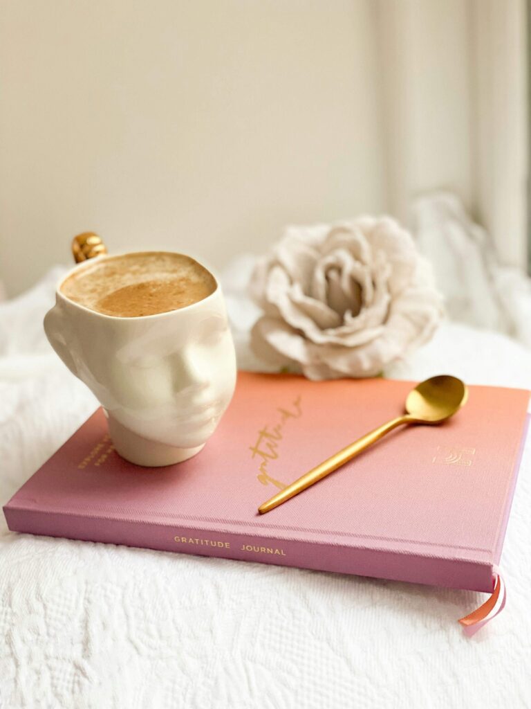 Relaxing morning scene with tea and journal, practicing self-care while setting intentions for the day