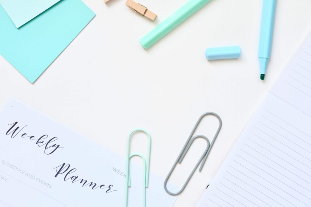 Flat lay of daily planner, pen, and sticky notes, showing steps for setting intentions for the day