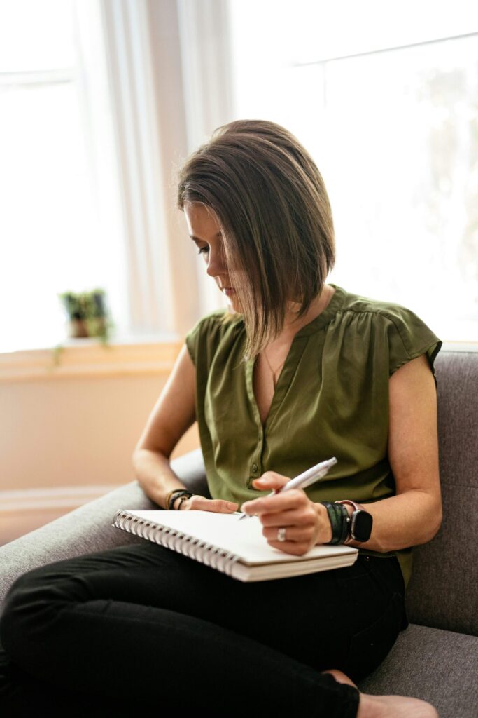 Woman writing in a gratitude journal as part of setting intentions for the day