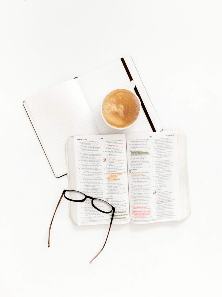 Notebook with daily intentions written down, surrounded by coffee and glasses