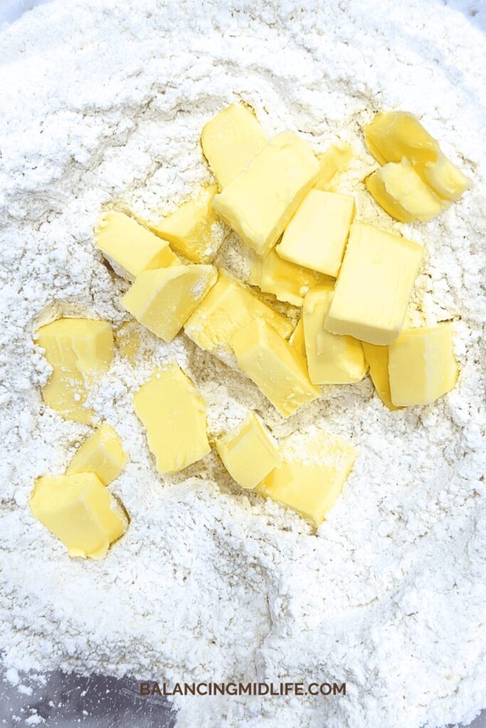 butter cut up in bowl of flour