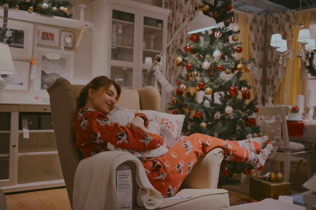 woman relaxed in christmas pajamas by the christmas tree for a mindful holiday