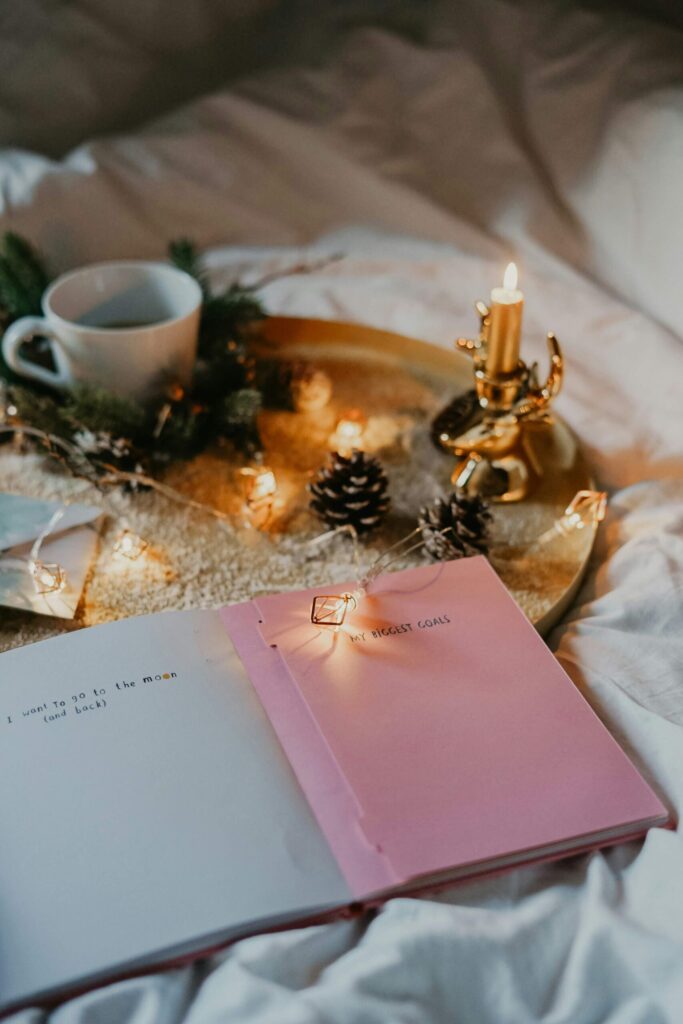 journal, candle and a cup of tea in a holiday setting for mindful holidays