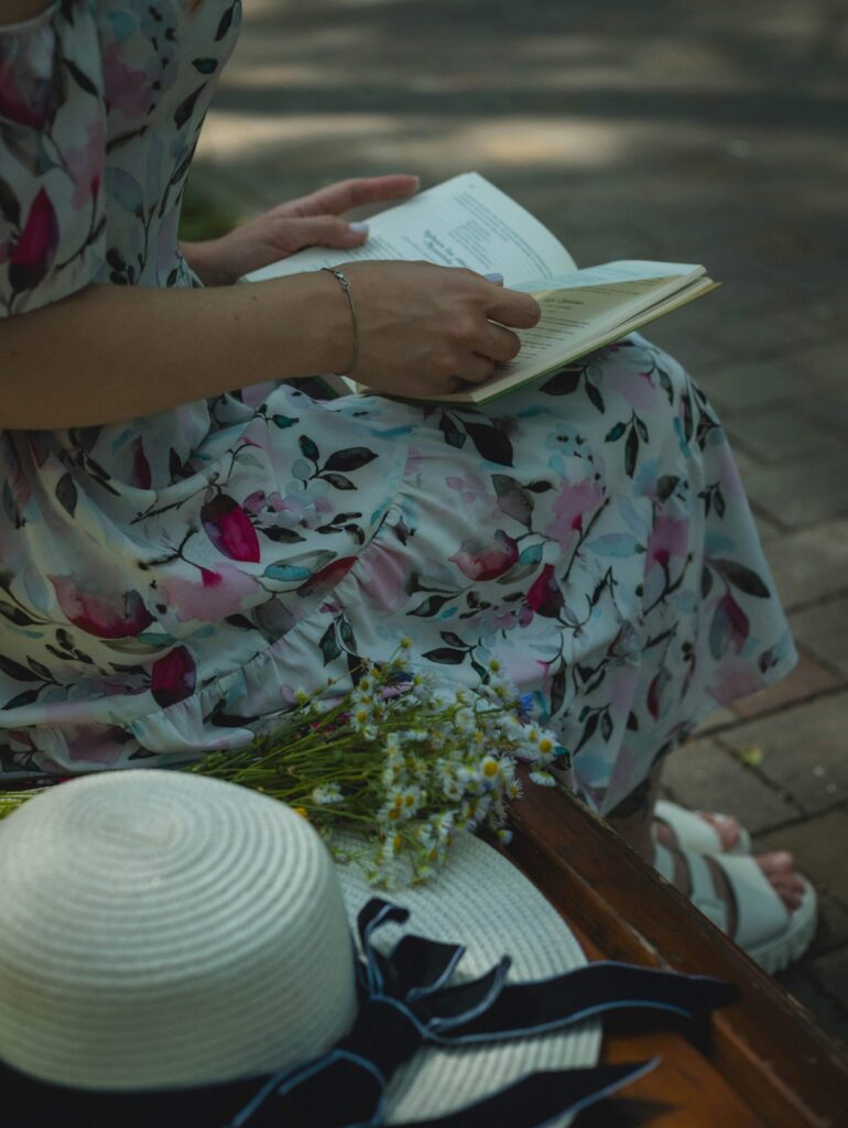 Midlife woman journaling outdoors in spring, practicing mindfulness and reflection prompts