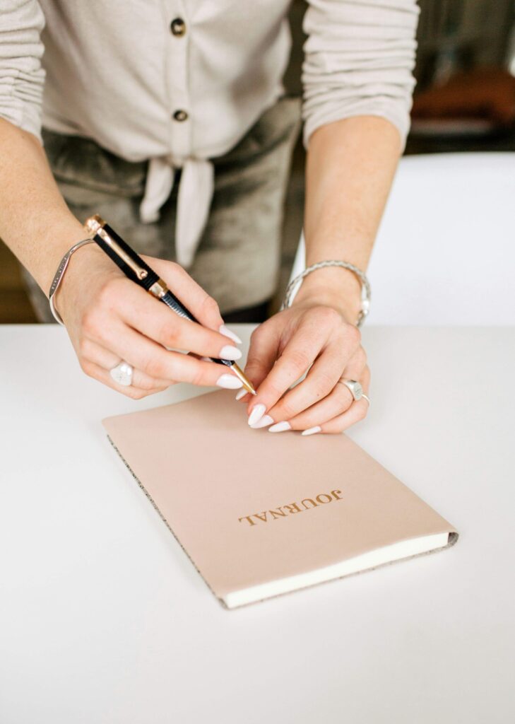 Midlife woman with a closed journal with spring sunlight, practicing spring journal prompts