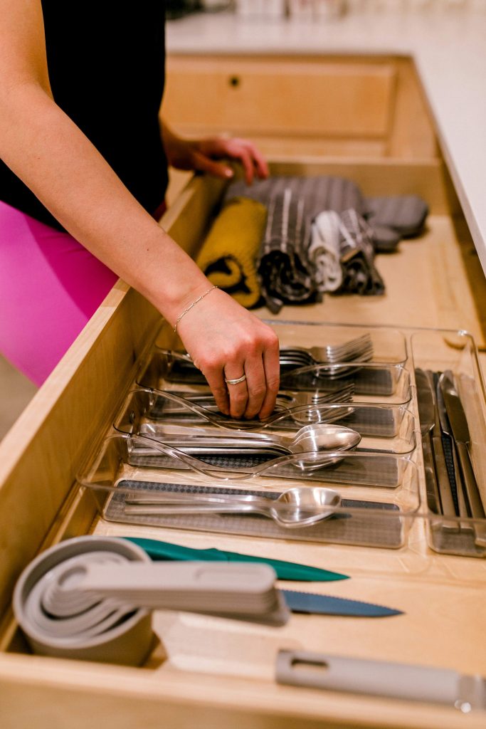 Woman organizing a small area of her home as part of simplifying and reducing clutter.