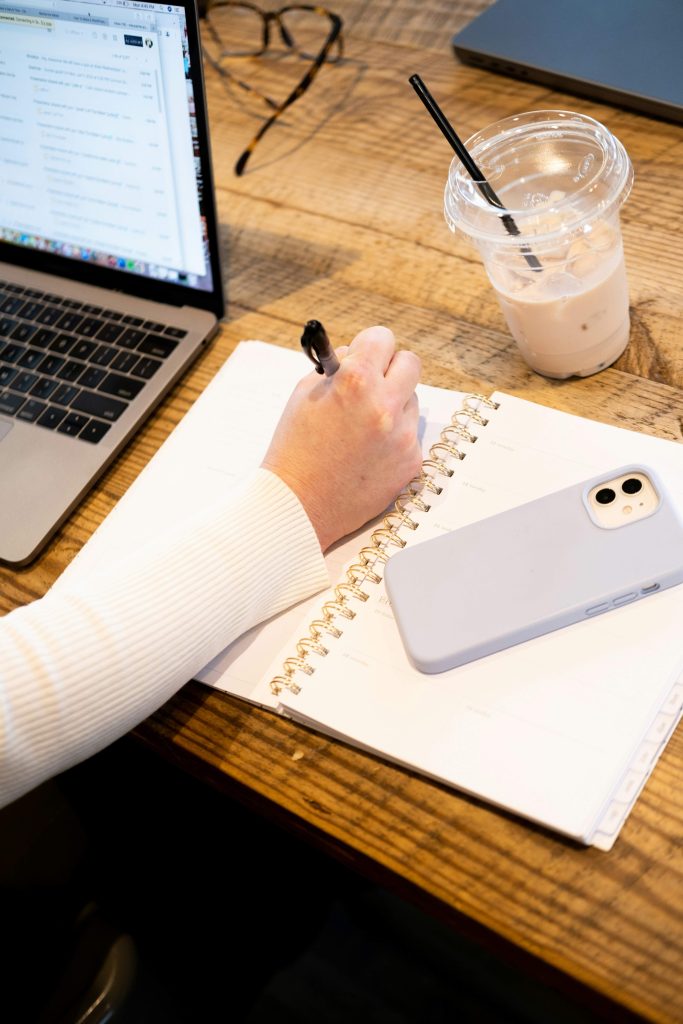 Woman writing in a notebook to organize her thoughts and simplify her mental load.