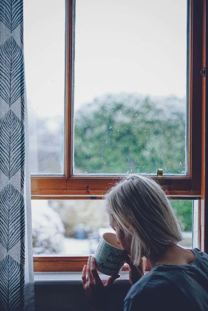 Woman enjoying a quiet moment at home while reflecting on what matters most and simplifying her life.